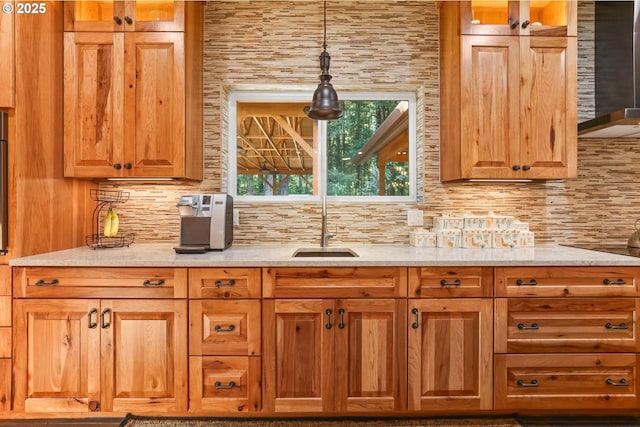 39100 SE Tumala Mountain Rd, Estacada, OR 97023 - kitchen with backsplash, light stone counters, a sink, hanging light fixtures, and glass insert cabinets