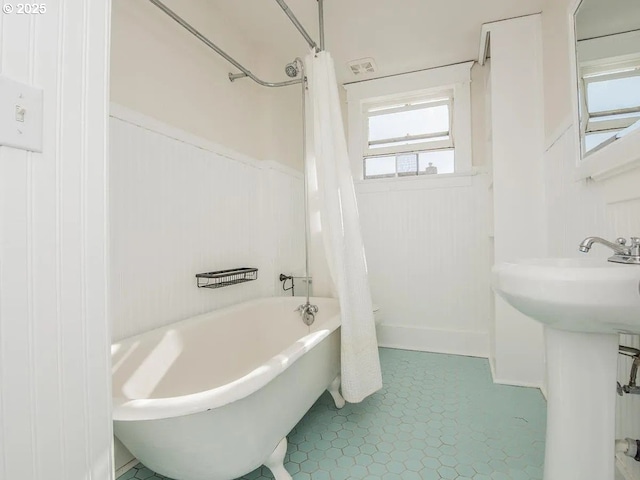 1236 N Emerson St, Portland, OR 97217 - bathroom featuring a wainscoted wall, shower / bath combo with shower curtain, tile patterned flooring, and a sink