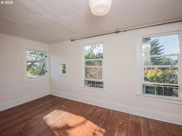 1236 N Emerson St, Portland, OR 97217 - unfurnished room featuring dark wood-type flooring, baseboards, a textured ceiling, and plenty of natural light