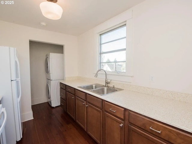 1236 N Emerson St, Portland, OR 97217 - kitchen featuring stacked washer and clothes dryer, freestanding refrigerator, a sink, dark wood-type flooring, and light countertops