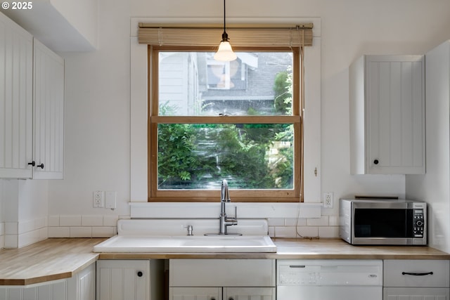1236 N Emerson St, Portland, OR 97217 - kitchen with stainless steel microwave, white dishwasher, white cabinets, and backsplash