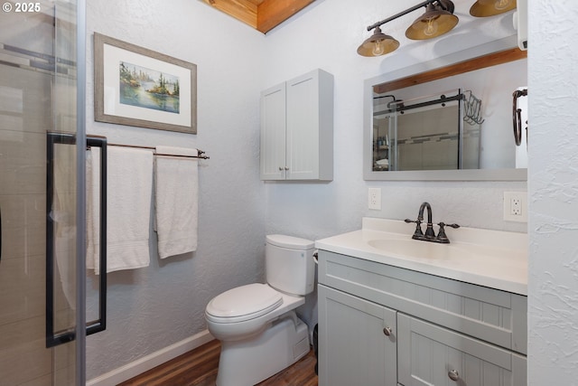 225 4th St, Otter Rock, OR 97369 - bathroom featuring wood finished floors, vanity, toilet, a textured wall, and a tile shower
