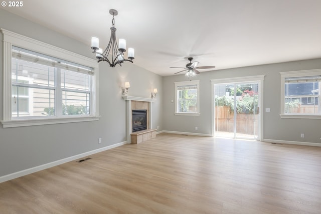 1507 Bogart Ln, Eugene, OR 97401 - unfurnished living room with light wood-style flooring, ceiling fan, a fireplace, and a chandelier