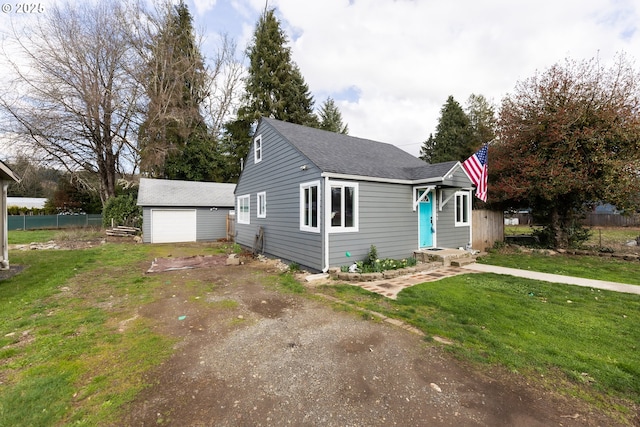 bungalow-style home featuring a detached garage, fence, a front lawn, and an outdoor structure