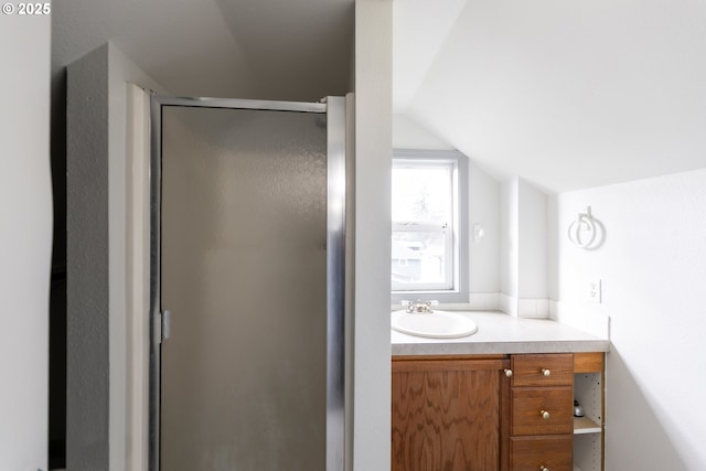 full bathroom with lofted ceiling, vanity, and a shower stall