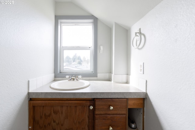 bathroom with vaulted ceiling and vanity