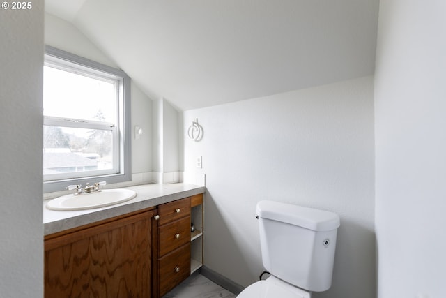 bathroom featuring vaulted ceiling, marble finish floor, vanity, and toilet