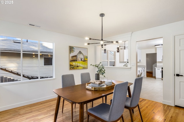 dining space with an inviting chandelier and light hardwood / wood-style floors