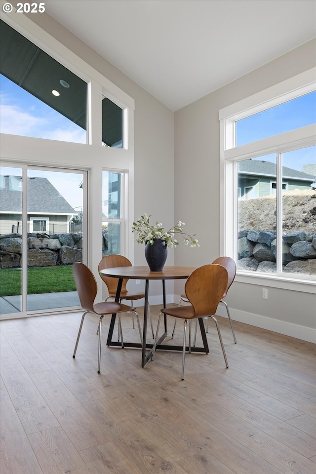 dining area featuring vaulted ceiling and light wood-type flooring