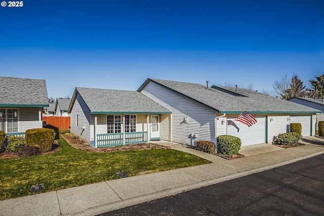 view of front facade featuring a porch, an attached garage, fence, roof with shingles, and a front yard