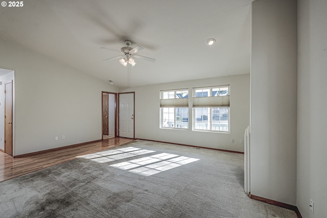 carpeted spare room featuring ceiling fan, visible vents, and baseboards