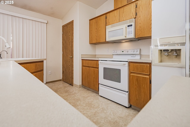 kitchen with brown cabinets, white appliances, baseboards, and light countertops