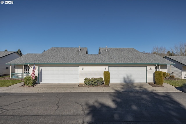 view of front facade with a shingled roof, concrete driveway, and an attached garage