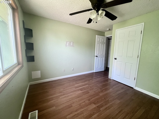 940 W Madrona Ave, Hermiston, OR 97838 - unfurnished bedroom with dark wood-type flooring, a textured ceiling, and a ceiling fan
