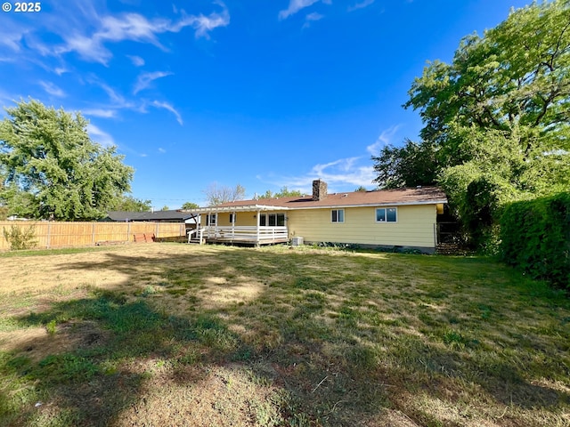 940 W Madrona Ave, Hermiston, OR 97838 - rear view of property with a fenced backyard, a wooden deck, and a chimney