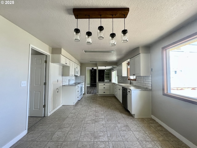 940 W Madrona Ave, Hermiston, OR 97838 - kitchen featuring decorative backsplash, a textured ceiling, white microwave, white cabinetry, and black dishwasher