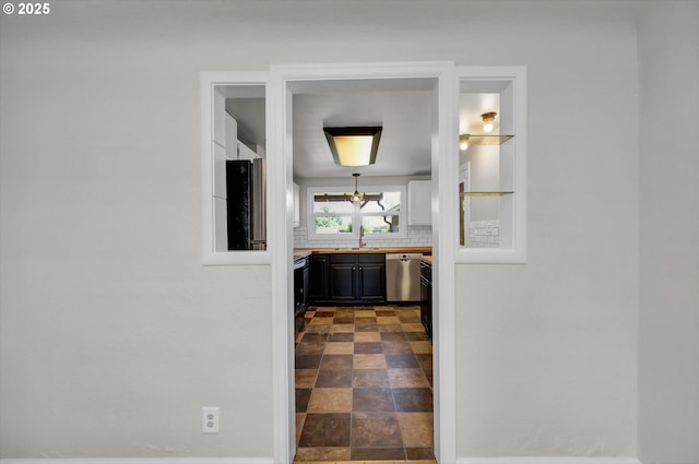 1119 7th St, Springfield, OR 97477 - corridor featuring a sink, a chandelier, dark stone finish flooring, and baseboards