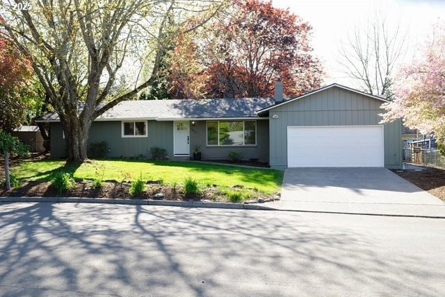 ranch-style house with a garage, driveway, and a front yard