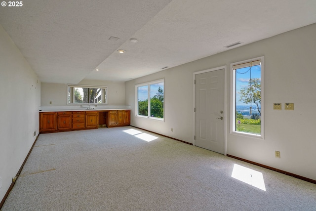 3794 E Nanitch Cir S, Salem, OR 97306 - kitchen with brown cabinetry, light colored carpet, a textured ceiling, baseboards, and light countertops