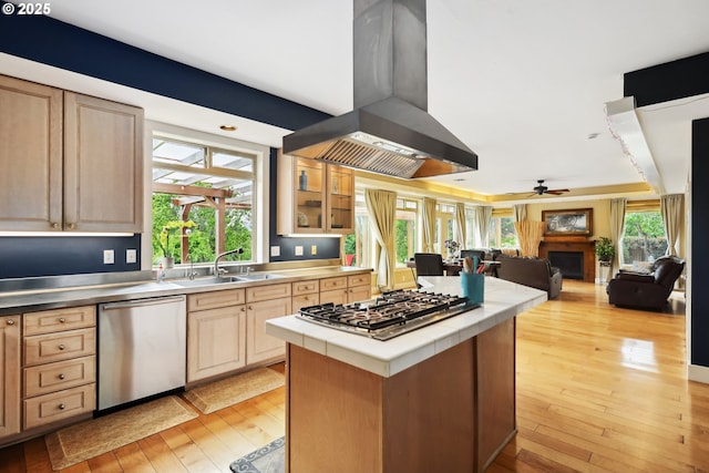 152 Palos Verdes, White Salmon, WA 98672 - kitchen featuring appliances with stainless steel finishes, island range hood, a sink, tile counters, and light wood-style floors