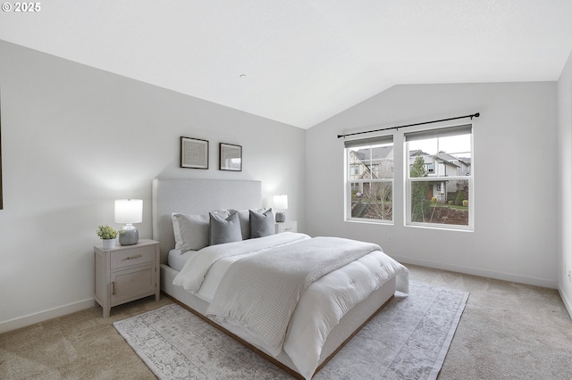 bedroom with light carpet, baseboards, and lofted ceiling