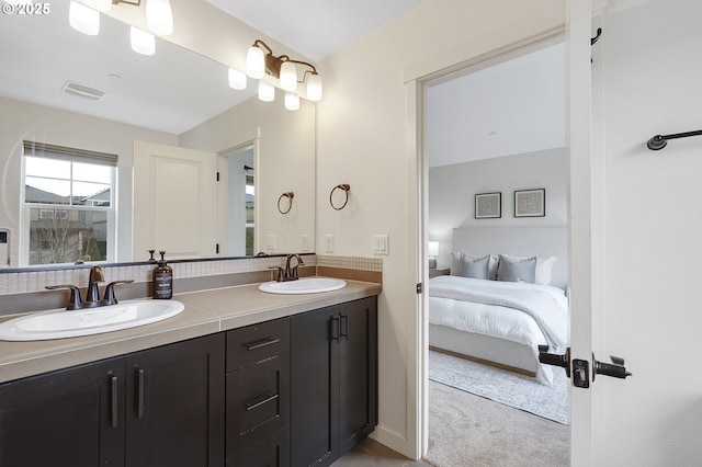 ensuite bathroom featuring double vanity, ensuite bath, a sink, and visible vents