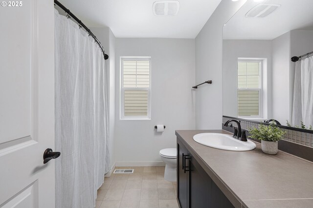 bathroom featuring visible vents, toilet, vanity, baseboards, and tile patterned floors