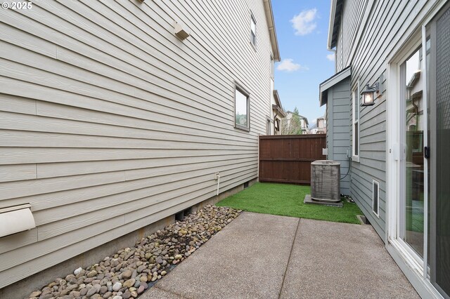 view of yard featuring fence, central AC unit, and a patio