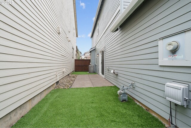 view of side of property featuring a yard and fence