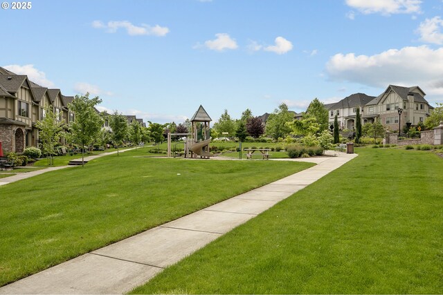 view of home's community with playground community, a yard, and a residential view