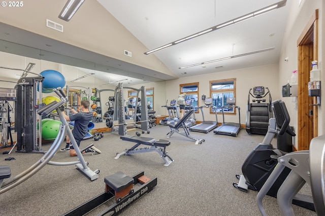 exercise room with high vaulted ceiling, baseboards, and visible vents