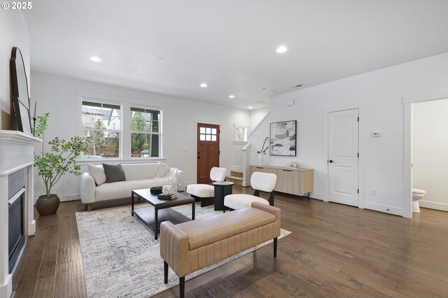 living area with a fireplace, baseboards, dark wood finished floors, and recessed lighting