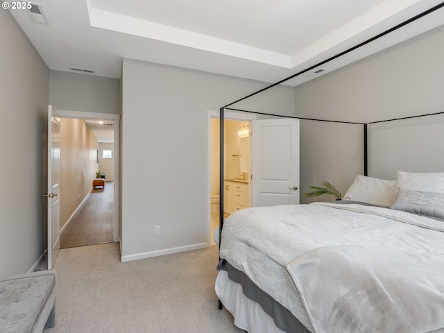 carpeted bedroom featuring ensuite bath