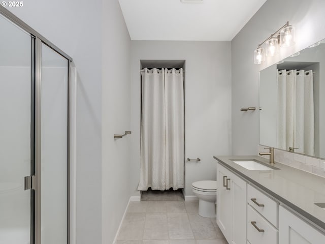 bathroom with toilet, vanity, tile patterned flooring, and walk in shower