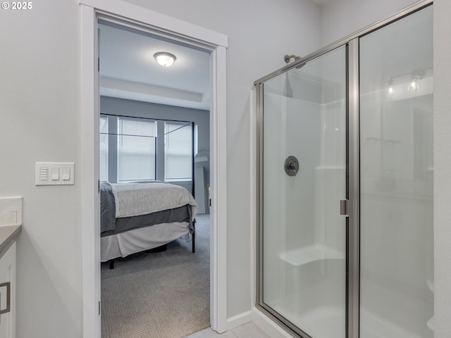 bathroom featuring a shower with door and vanity