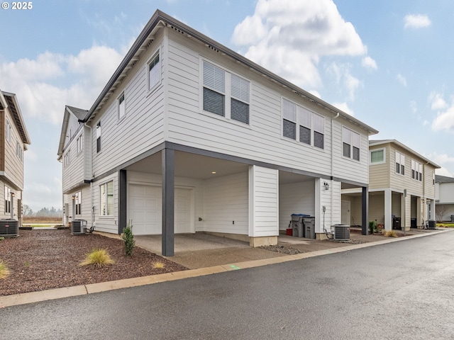 view of front of home with central air condition unit and a garage