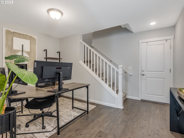 home office with a textured ceiling and wood-type flooring