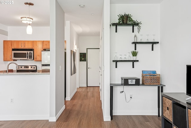 1125 NW 9th Ave Unit 427, Portland, OR 97209 - kitchen with stainless steel microwave, wood finished floors, electric stove, and open shelves
