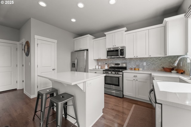 1012 NE 11th Ct, Battle Ground, WA 98604 - kitchen with appliances with stainless steel finishes, recessed lighting, a center island, a kitchen bar, and tasteful backsplash