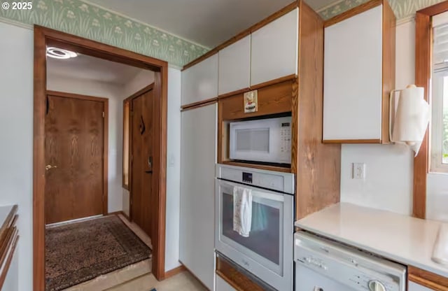 kitchen with white cabinetry and white appliances