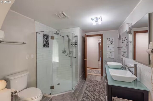 bathroom featuring vanity, toilet, and an enclosed shower