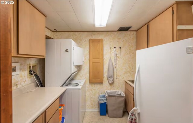 kitchen with stacked washer and clothes dryer and white fridge