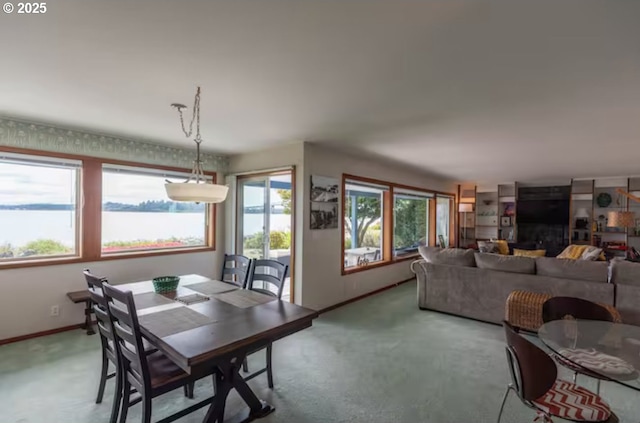 carpeted dining space featuring a water view