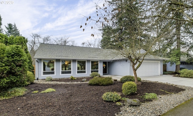 view of front of house featuring concrete driveway, an attached garage, and roof with shingles