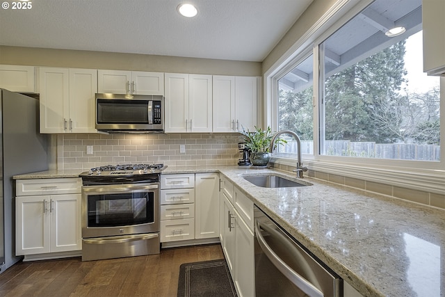 kitchen featuring white cabinetry, stainless steel appliances, and a sink