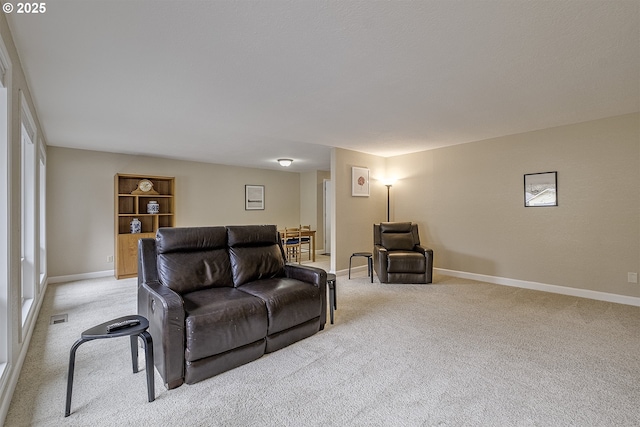 living area with light carpet, visible vents, and baseboards