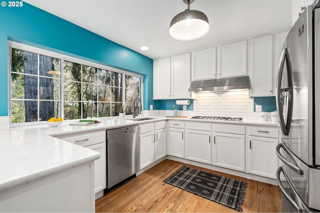 kitchen with sink, light hardwood / wood-style flooring, stainless steel appliances, and white cabinets