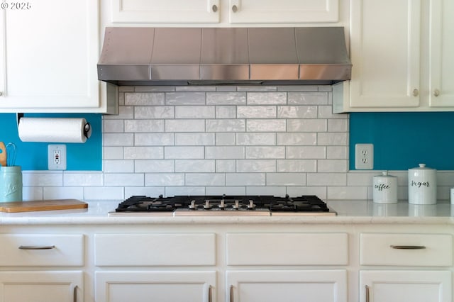 kitchen featuring white cabinetry, backsplash, gas stovetop, and range hood