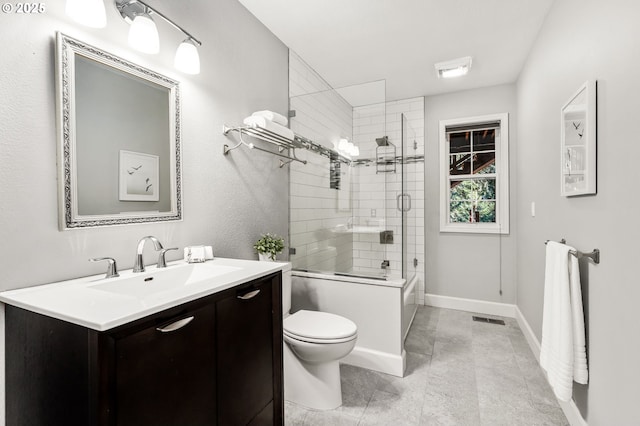 full bathroom featuring bath / shower combo with glass door, vanity, and toilet