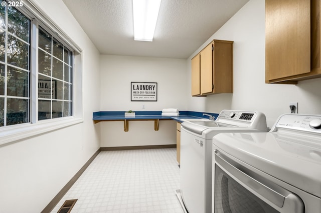 washroom with cabinets, separate washer and dryer, and a textured ceiling